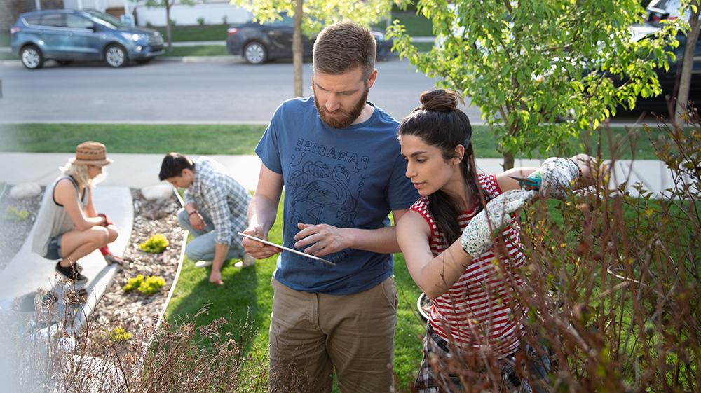 Scanning their ipad outside, a couple review their condo maintenance checklist.